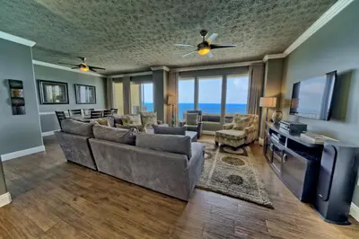 a living room with a couch and a tv at Pleasant Oceanfront Condo with Large Balcony and Beach Access - Unit 1605 in Panama City Beach