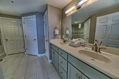a bathroom with two sinks and a large mirror at Pleasant Oceanfront Condo with Large Balcony and Beach Access - Unit 1605 in Panama City Beach