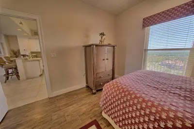 a bedroom with a bed and a window and a dresser at Stunning 16th Floor Condo with Fitness Center, Hot Tubs, Pools, and Beach Access - Unit 1606 in Panama City Beach