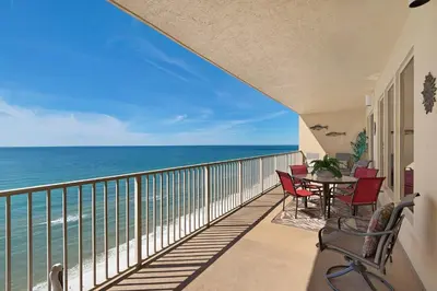 a balcony with a table and chairs and the ocean at Stunning 16th Floor Condo with Fitness Center, Hot Tubs, Pools, and Beach Access - Unit 1606 in Panama City Beach