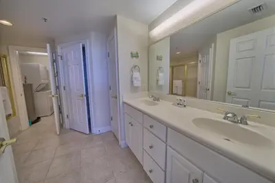 a bathroom with two sinks and a large mirror at Stunning 16th Floor Condo with Fitness Center, Hot Tubs, Pools, and Beach Access - Unit 1606 in Panama City Beach