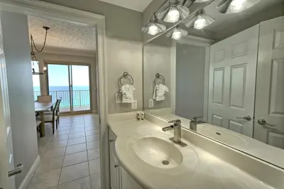 a bathroom with a sink and a mirror and a table at Gulf Front Condo with Beach Access and Beachside Pool - Unit 1604 in Panama City Beach