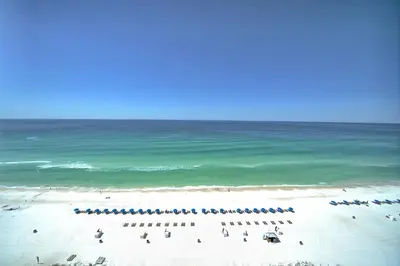 a group of people on a beach near the ocean at Gulf Front Condo with Beach Access and Beachside Pool - Unit 1604 in Panama City Beach