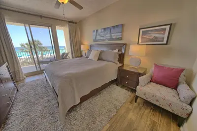 a bedroom with a bed and a chair and a window at Astonishing Oceanfront Condo with Oversized Balcony to Enjoy Amazing Gulf View - Unit 0204 in Panama City Beach