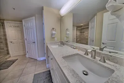 a bathroom with two sinks and a large mirror at Astonishing Oceanfront Condo with Oversized Balcony to Enjoy Amazing Gulf View - Unit 0204 in Panama City Beach