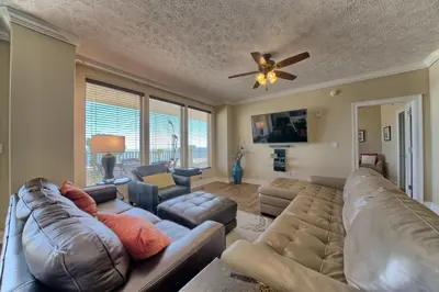 a living room with a couch and a ceiling fan at Astonishing Oceanfront Condo with Oversized Balcony to Enjoy Amazing Gulf View - Unit 0204 in Panama City Beach