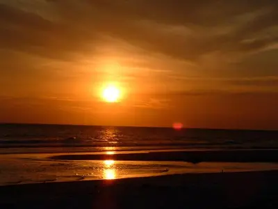 a sunset on the beach with the sun setting at Villa Paradise, Pet Friendly in Panama City Beach