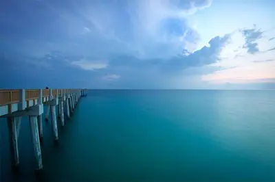 a pier on the water with a blue sky at Villa Paradise, Pet Friendly in Panama City Beach