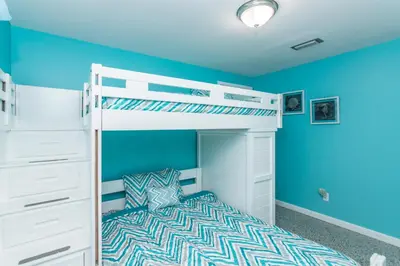 a bedroom with blue walls and a bunk bed at Villa Serenity, Pet Friendly in Panama City Beach