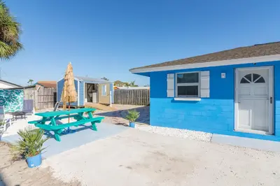 a blue house with a picnic table in front of it at Villa Serenity, Pet Friendly in Panama City Beach