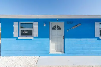 a blue house with a door and a window at Villa Serenity, Pet Friendly in Panama City Beach