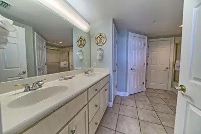 a bathroom with a sink and a mirror at Tropical Gulf Front Condo with Picnic Area & Grills - Unit 0802 in Panama City Beach