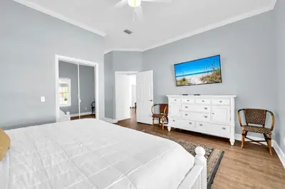 a white bedroom with a white bed and a dresser at Fishers in Panama City Beach