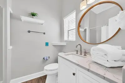 a white bathroom with a sink and a mirror at Fishers in Panama City Beach