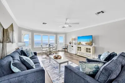 a living room with two blue couches and a tv at Fishers in Panama City Beach