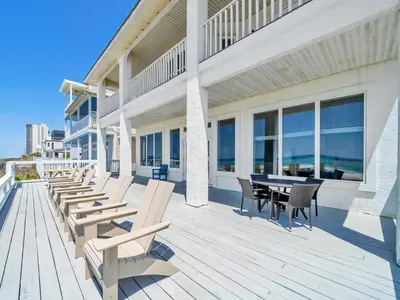 a wooden deck with tables and chairs on a building at Fishers in Panama City Beach