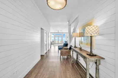 a hallway with white walls and a table with a lamp at Fishers in Panama City Beach