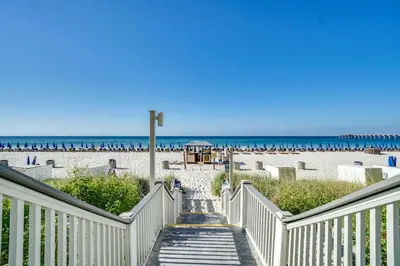 a stairway leading down to a beach with the ocean at Calypso Beach Resort in Panama City Beach