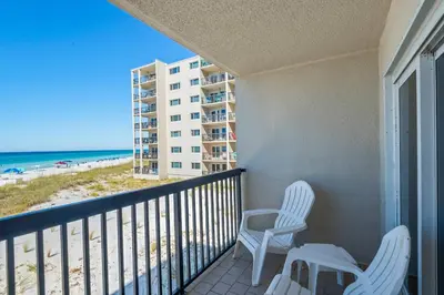 a balcony with two chairs and a view of the beach at Pinnacle Port C1-203 in Carillon Beach