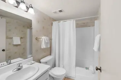 a bathroom with a toilet and a sink and a shower at Pinnacle Port C1-203 in Carillon Beach
