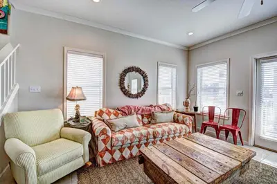 a living room with a couch and a table and chairs at Seabreeze Cottage #45 in Watersound Beach