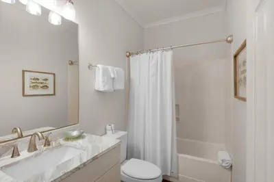 a white bathroom with a tub and a toilet and a sink at Seabreeze Cottage #45 in Watersound Beach