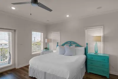 a bedroom with a bed with a blue dresser and windows at Seabreeze Cottage #45 in Watersound Beach