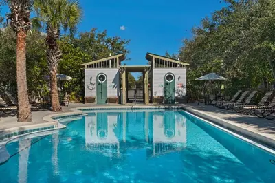 a swimming pool in front of a house with palm trees at 2 Blessed 2 Be Stressed in Watersound Beach