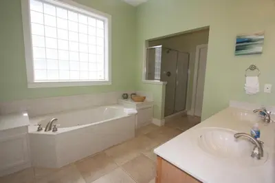 a bathroom with a tub and two sinks and a window at Grace Villa in Watersound Beach
