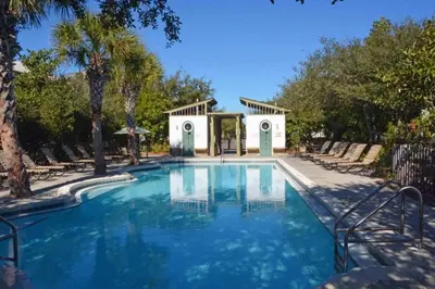 a swimming pool in a resort with chairs and trees at Grace Villa in Watersound Beach