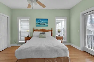 a bedroom with a large bed and two windows at Grace Villa in Watersound Beach