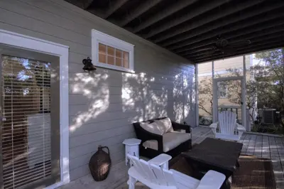 a patio with a couch and a chair on a porch at Beach Breeze in Watersound Beach