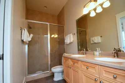 a bathroom with a shower and two sinks and a toilet at Beach Breeze in Watersound Beach