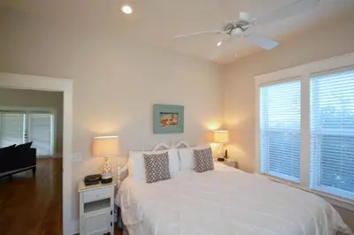a bedroom with a white bed and two windows at Beach Breeze in Watersound Beach