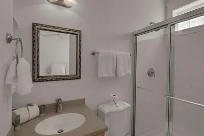 a bathroom with a toilet and a sink and a mirror at Beach Breeze in Watersound Beach