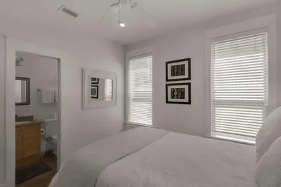 a white bedroom with a bed and a bathroom at Beach Breeze in Watersound Beach