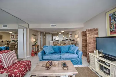 a living room with a blue couch and a tv at Pinnacle Port C1-302 in Carillon Beach