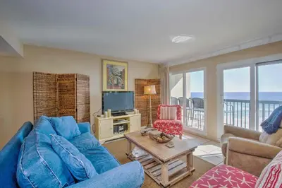 a living room with a blue couch and a tv at Pinnacle Port C1-302 in Carillon Beach