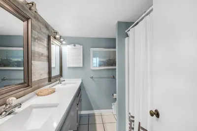 a bathroom with a sink and a mirror at Pinnacle Port C1-302 in Carillon Beach