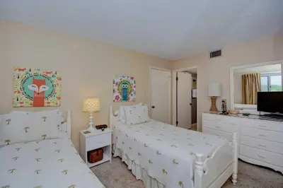 a bedroom with two beds and a flat screen tv at Pinnacle Port C1-302 in Carillon Beach