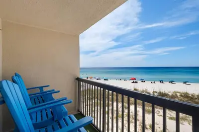 two blue chairs sitting on a balcony overlooking the beach at Pinnacle Port C1-302 in Carillon Beach