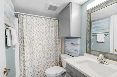 a bathroom with a toilet and a sink and a mirror at Pinnacle Port C1-302 in Carillon Beach