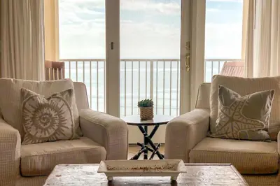 a living room with two chairs and a table at Key Largo in Seagrove Beach