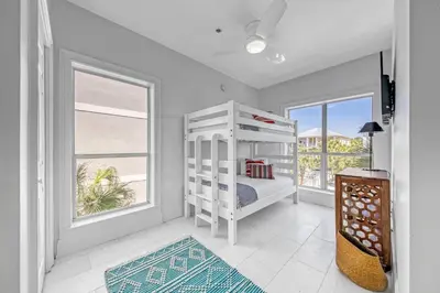 a bedroom with a bunk bed and two windows at Key Largo in Seagrove Beach