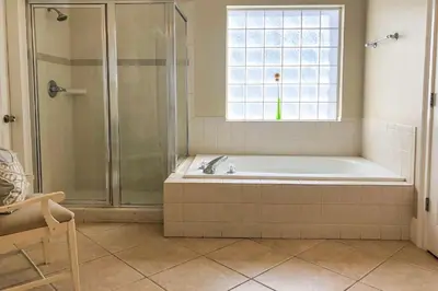a bathroom with a tub and a shower with a window at Key Largo in Seagrove Beach