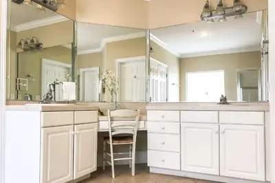 a bathroom with white cabinets and a large mirror at Key Largo in Seagrove Beach