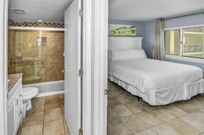 a bedroom with a bed and a shower and a bathroom at Pinnacle Port B3-307 in Carillon Beach