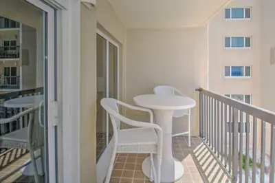 a balcony with a white table and chairs on it at Pinnacle Port B3-307 in Carillon Beach
