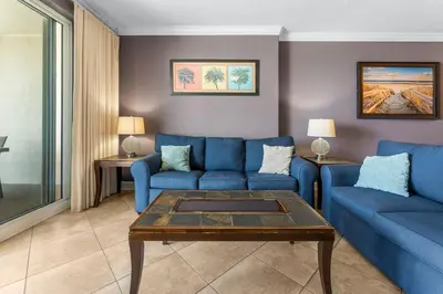 a living room with blue couches and a table at Ocean Reef Beach Resort! Beach Front! Free Seasonal Beach Chairs! by Dolce Vita Getaways PCB in Panama City Beach