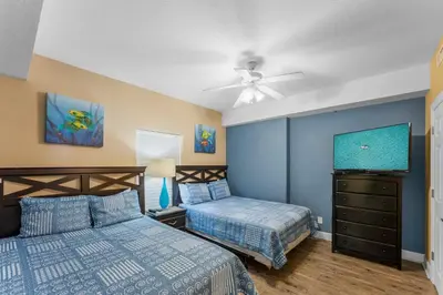 a bedroom with two beds and a ceiling fan at Ocean Reef Beach Resort! Beach Front! Free Seasonal Beach Chairs! by Dolce Vita Getaways PCB in Panama City Beach